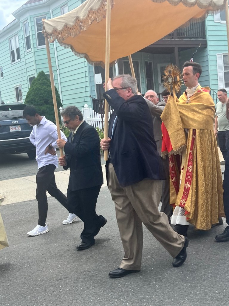 Image of the Blessed Sacrament held under a canopy during a procession